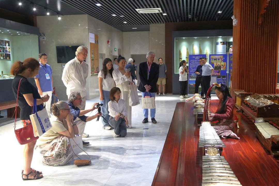 访问团成员观看广西艺术学院缅甸籍留学生德馨（thazinhtwe）演奏缅甸乐器“弯琴”（saung-gauk）.jpeg